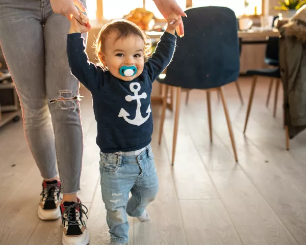 Redaktion für das Familienportal Kind läuft an der Hand seiner Mutter